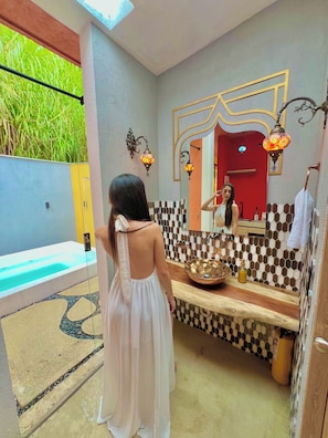 A bathroom with a tiled backsplash, a mirror, a sink, and a bathtub. - GLAMPING RAICES (Manizales)