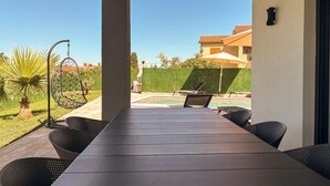 A covered outdoor seating area with a pool, chairs, and a hanging chair. - Cozy home in Nedescina (Nedescina)