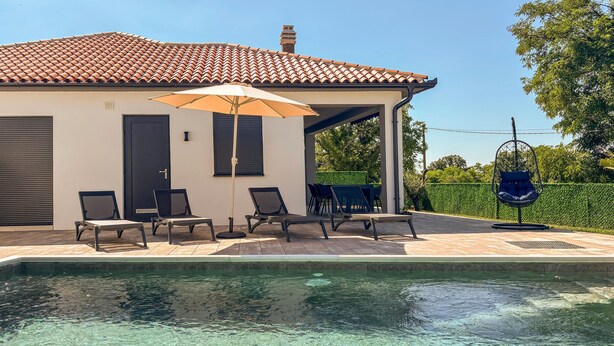 A poolside area with lounge chairs, a covered seating area, and a hanging chair. - Cozy home in Nedescina (Nedescina)