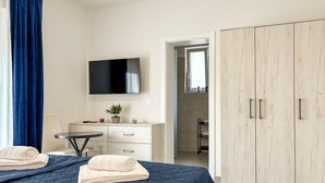 A bedroom with a bed, a TV, a desk, a wardrobe, and a bathroom visible through an open door. - Cozy home in Nedescina (Nedescina)