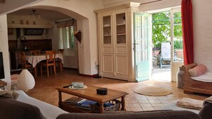 A living room with a TV, sofa, and dining area with a table and chairs. - Provencal house with private pool (MONS)