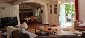 A living room with a TV, sofa, and dining area with a table and chairs. - Provencal house with private pool (MONS)
