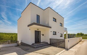 A modern two-story building with a flat roof, a balcony on the upper floor, and a front entrance with steps. - Beautiful home in Vodnjan (Vodnjan)