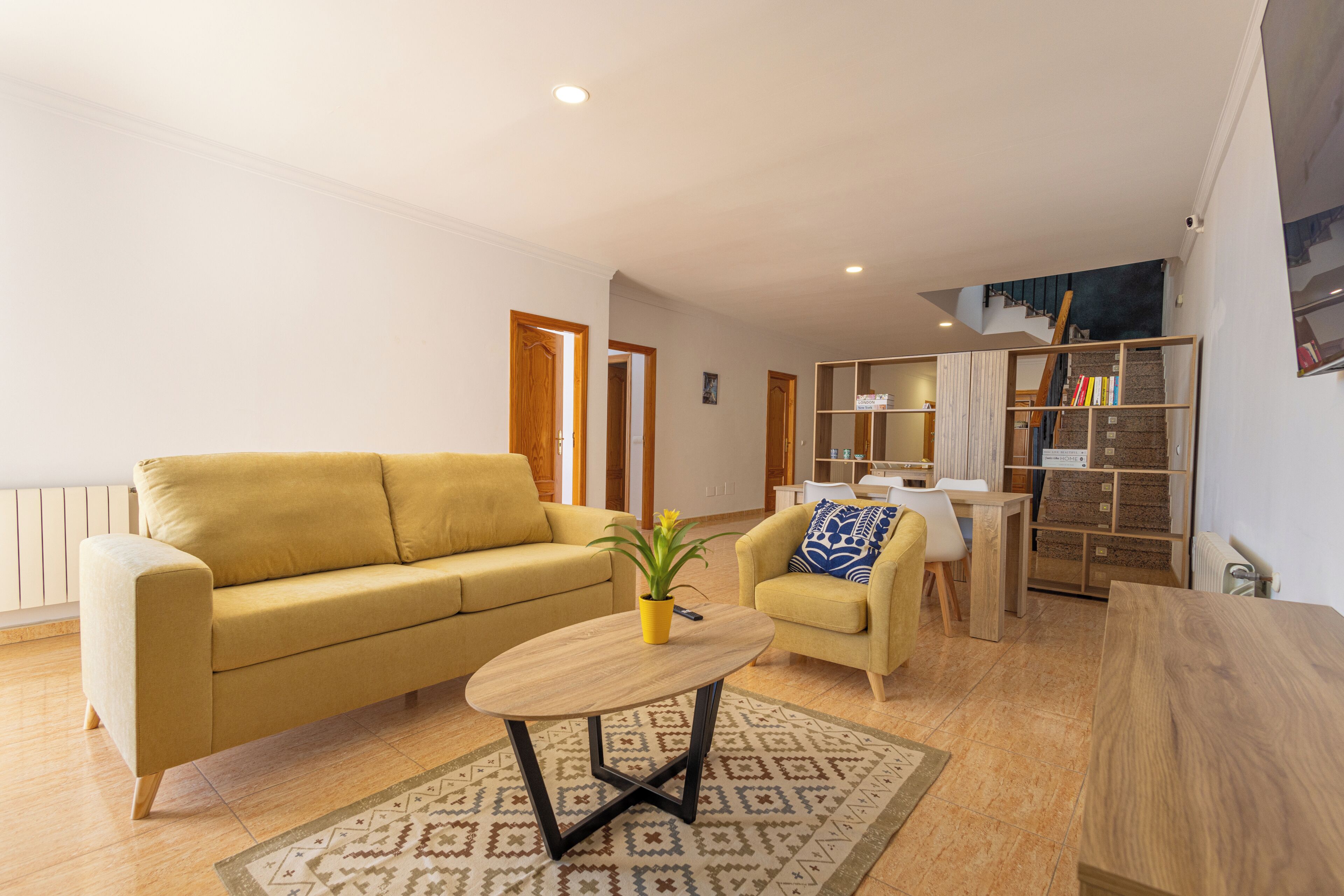 A living room with a sofa, a coffee table, a chair, and a bookshelf.