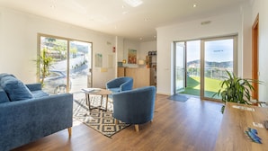 A spacious living area with a sofa, armchairs, a coffee table, and a view of the outdoors.