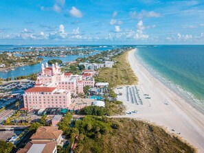 Ein Küstenhotel mit einem großen Gebäude, einem Strand und einer Marina.