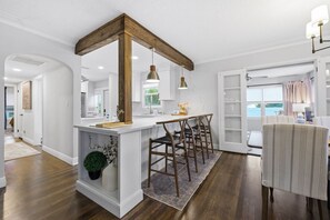 Eine moderne Küche mit einer zentralen Kochinsel, Holzkohle und Blick ins Freie.