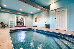 A swimming pool with a tiled deck, a door, and a chair. - Beaver's Mountaintop Retreat! Pool Cabin | Top 5% (Pigeon Forge)