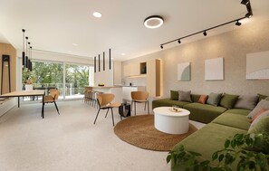 A modern living room with a sofa, coffee table, and dining area with chairs. - Cozy home in Malinska with sauna (Malinska)