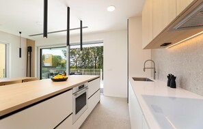 A modern kitchen with a large island, built-in oven, and a view to the outside. - Cozy home in Malinska with sauna (Malinska)