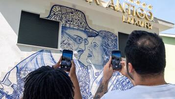 A building with a sign reading 'SOLAR ANTICO LUXURY' and a mural with a face.