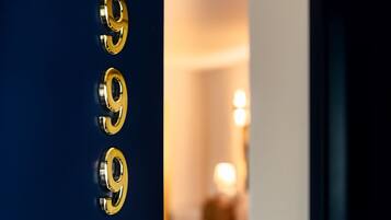 Uma porta com três números dourados '9', indicando o número de um quarto de hotel.