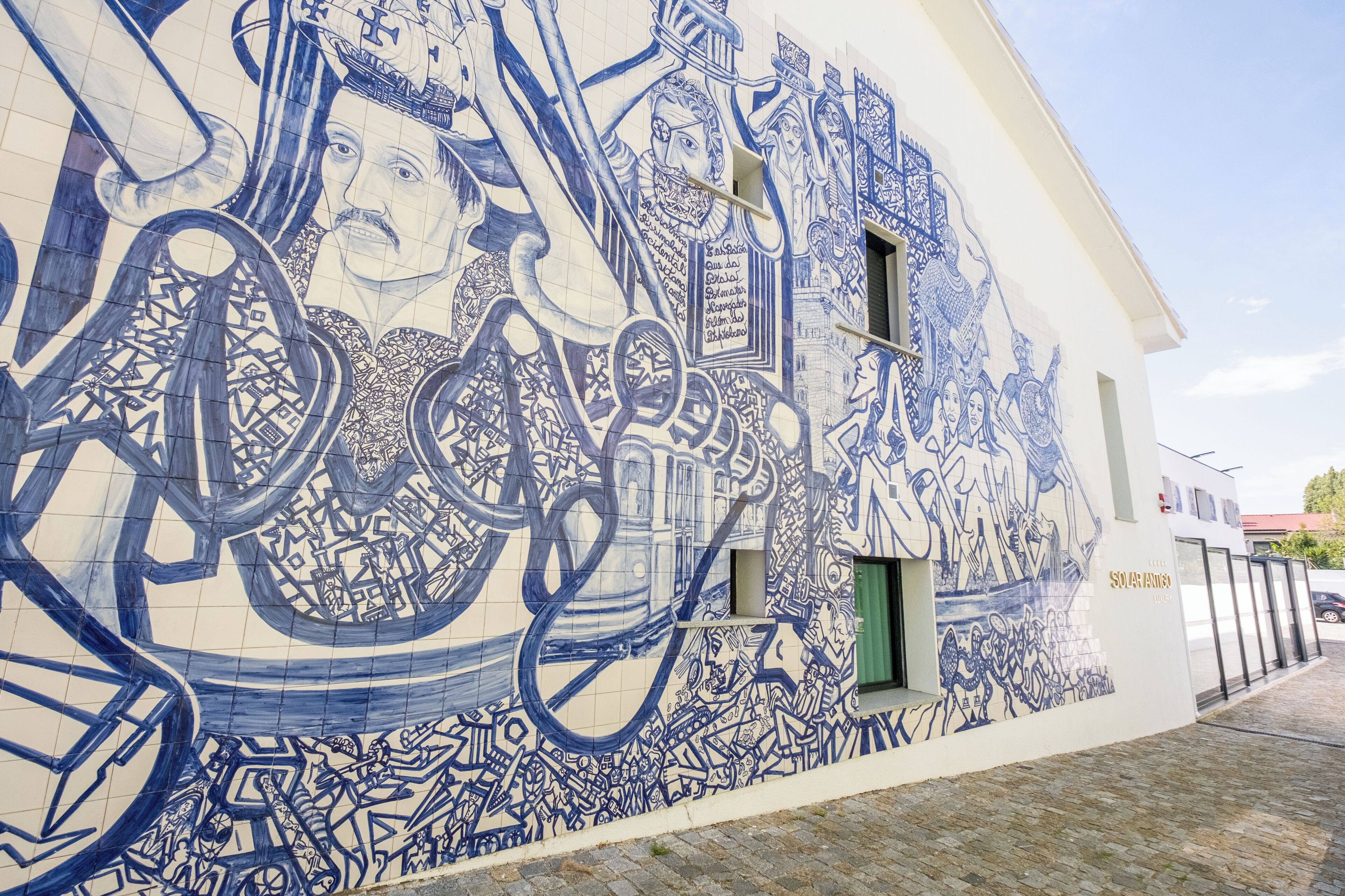 A building with a large blue and white mural on its exterior wall.