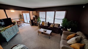 A living room with a sofa, coffee table, TV, and a plant. - Your FIFA World Cup Base Camp-6 miles from the stadium (Raytown)