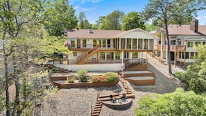 A two-story house with a balcony, a deck, and a fire pit area.