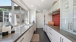 Eine moderne Küche mit einer langen Arbeitsplatte, einem Spülbecken und einem Fenster.