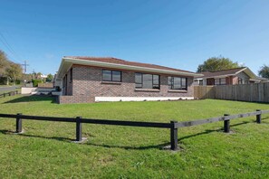 A single-story brick house with a fenced yard.