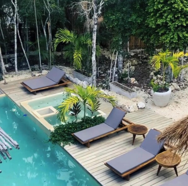 A poolside area with lounge chairs, a small pool, and surrounding greenery. - Luxury Jungle Villa | Pool, Sauna, Rooftop (Tulum)