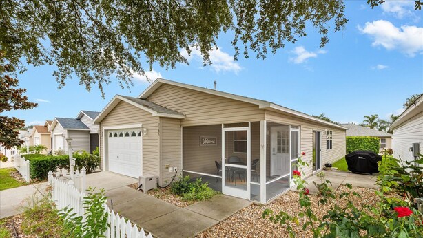 Ein Bungalow mit Garage, überdachter Veranda und kleinem Garten.