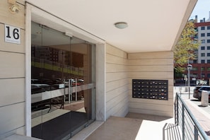 A building entrance with a glass door, a mailbox, and a street view. - Colinas Premium 3BR - Three Bedroom Apartment, Sleeps 5 (Sintra)