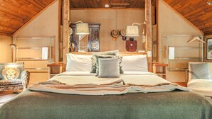Un dormitorio acogedor con una cama grande, techo de madera y decoración rústica.