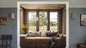 A cozy seating area with a bench, cushions, and a vase of flowers. - Hideaway Round Top | Full Property | 21-Acre Luxury Estate (Round Top)