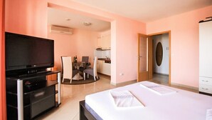 Une chambre d’hôtel équipée d’un lit, d’une télévision, d’un bureau et d’une kitchenette.
