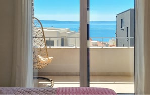 Ein Balkon mit Blick auf das Meer und Gebäude.