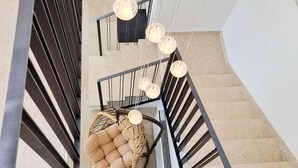 A staircase with a cushioned chair and hanging pendant lights. - Beautiful home in Makarska (Makarska)