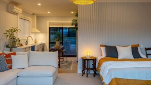 Een moderne slaapkamer met een bed, een bank, een kleine tafel en een lamp.