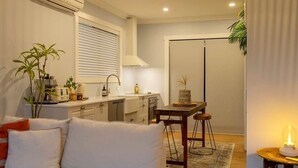 Een compacte woonruimte met een kitchenette, een eethoek en een gezellige zithoek.