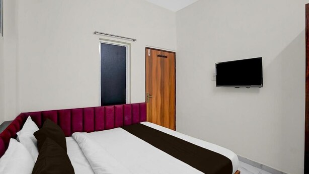 Une chambre à coucher avec un lit, une télévision, une porte et une fenêtre.