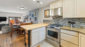Una cocina moderna con una isla central, electrodomésticos de acero inoxidable y salpicadero de azulejos.