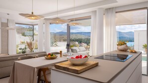 Cozinha moderna com uma ilha grande, espaço para refeições e vista para as montanhas.