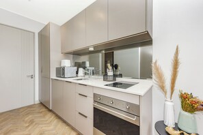 Eine moderne Küche mit Mikrowelle, Kaffeemaschine und Backofen.