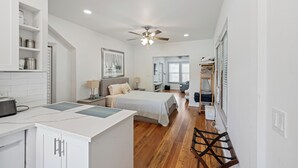 Um quarto moderno com cama, mesa de cabeceira e ventilador de teto.