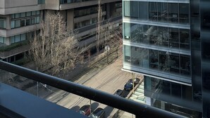 Een modern gebouw met reflecterende glasramen, een zichtbaar parkeerterrein en een heldere lucht.