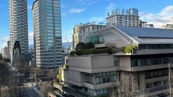 A cityscape with modern buildings, a parking lot, and a clear sky.