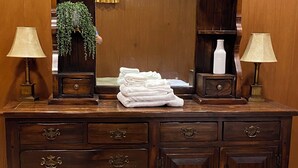 Een houten dressoir met meerdere lades en een spiegel erboven.