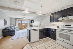 A modern kitchen with dark cabinets, a white countertop, and a built-in oven.
