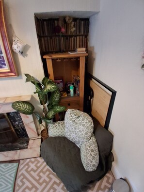 A corner room with a wooden cabinet, a green plant, patterned cushions, and a tiled floor. - Wexford 3br Townhouse With Private Garden (Wexford)