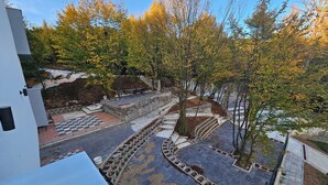 A courtyard with a checkered pavement, trees, and a bench area.