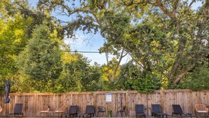A swimming pool with lounge chairs and a wooden fence. - A Porter Retreat • 2BR Walk to Downtown OS (Ocean Springs)