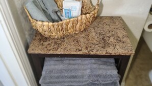 Una cesta tejida con una toalla y una caja sobre una encimera.