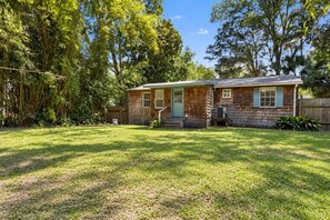 A single-story wooden house with a front porch, a small front yard, and a bamboo fence. - The Downtown Cedar - walk to Government St & Washington (Ocean Springs)