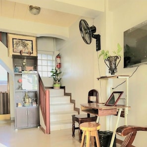 A staircase leading to a landing with a fan, a TV, and a small table with a laptop. - AMA is 2 floor levels unit in a 4 storey building,3 BR, 2 Bath in Sevilla Norte (San Fernando City)