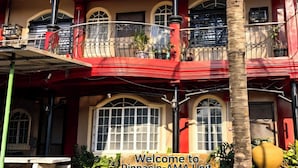 Un edificio con balcón rojo, múltiples ventanas y un cartel dando la bienvenida a visitantes a Pinnacle-AMA Unit.