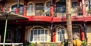 A building with a red balcony, multiple windows, and a sign welcoming visitors to Pinnacle-AMA Unit.