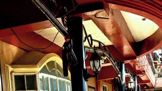 Un espacio al aire libre cubierto con una ventana, plantas en macetas y un farol.