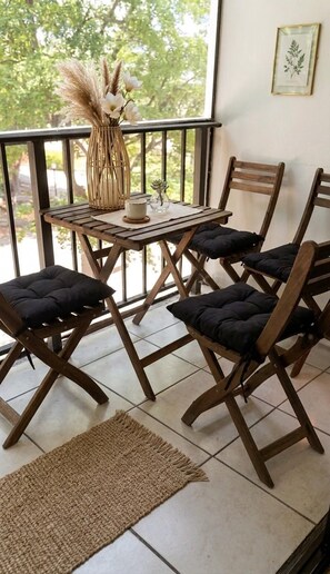 A wooden dining table with cushioned chairs, a woven vase with pampas grass, and a framed botanical print on the wall. - Beach Apartment Sunny Isles Steps from the Beach (Sunny Isles Beach)